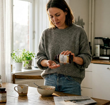 En kvinde gør klar til at tage sine vitaminer i køkkenet.