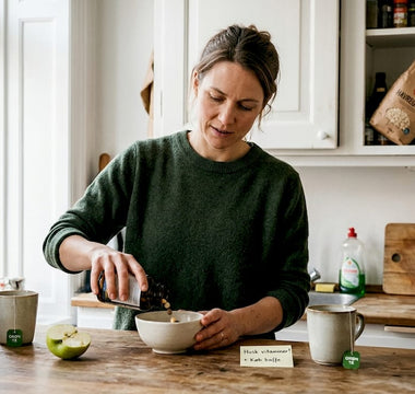 En kvinde står hjemme i sit køkken og doserer vitaminer.