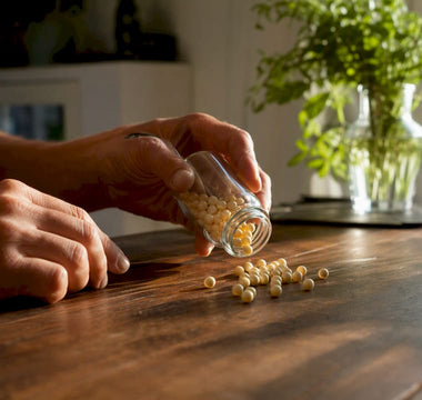 Hænder, der hælder B12-vitamin-kapsler op