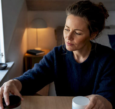 En person sammenligner to søvnløsninger ved sengebordet